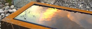 Corten Steel Trough sky reflected in water surface
