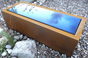 Corten Steel Trough, water reflecting blue sky