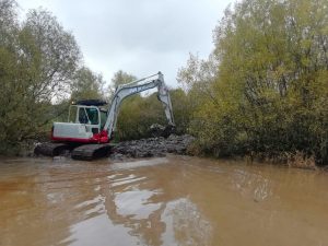 Callander Froglife - mechanical digger working in muddy water, excavating the pond.