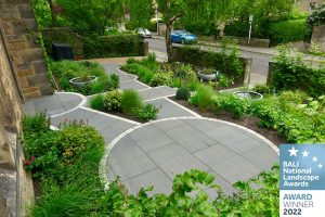 Accessible garden showing garden planting, granite paths, ramps and wheelchair turning areas. BALI Award 2022 Badge in bottom right hand corner of image