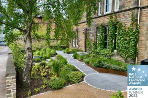 Photo of accessible garden showing resin-bound parking area, garden planting and granite ramps and wheelchair turning areas